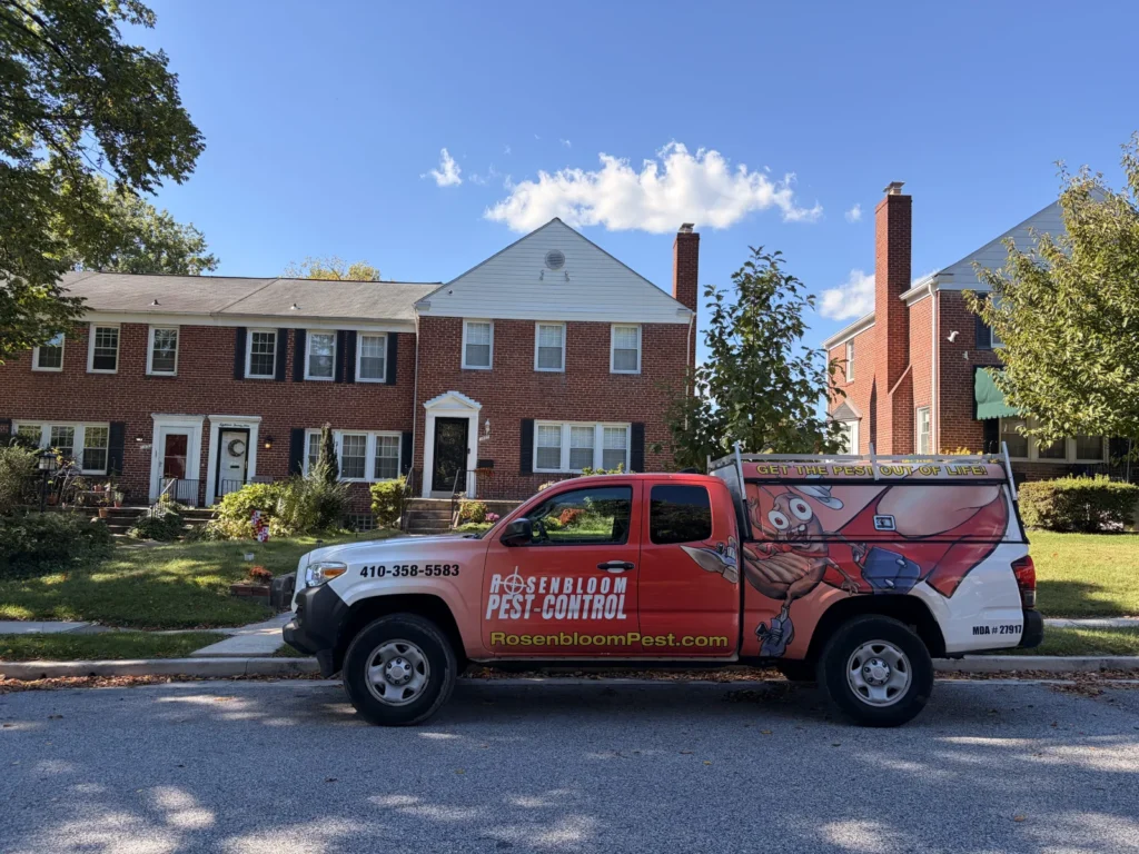 Rosenbloom Pest Control service truck on a neighborhood street with brick rowhomes behind it